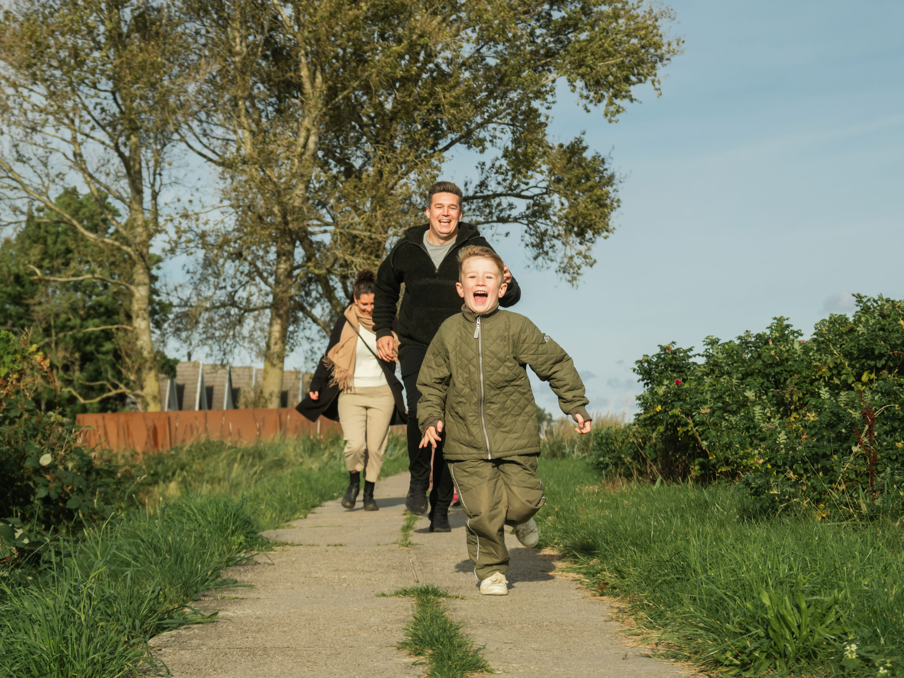 Familie med barn løber på sti
