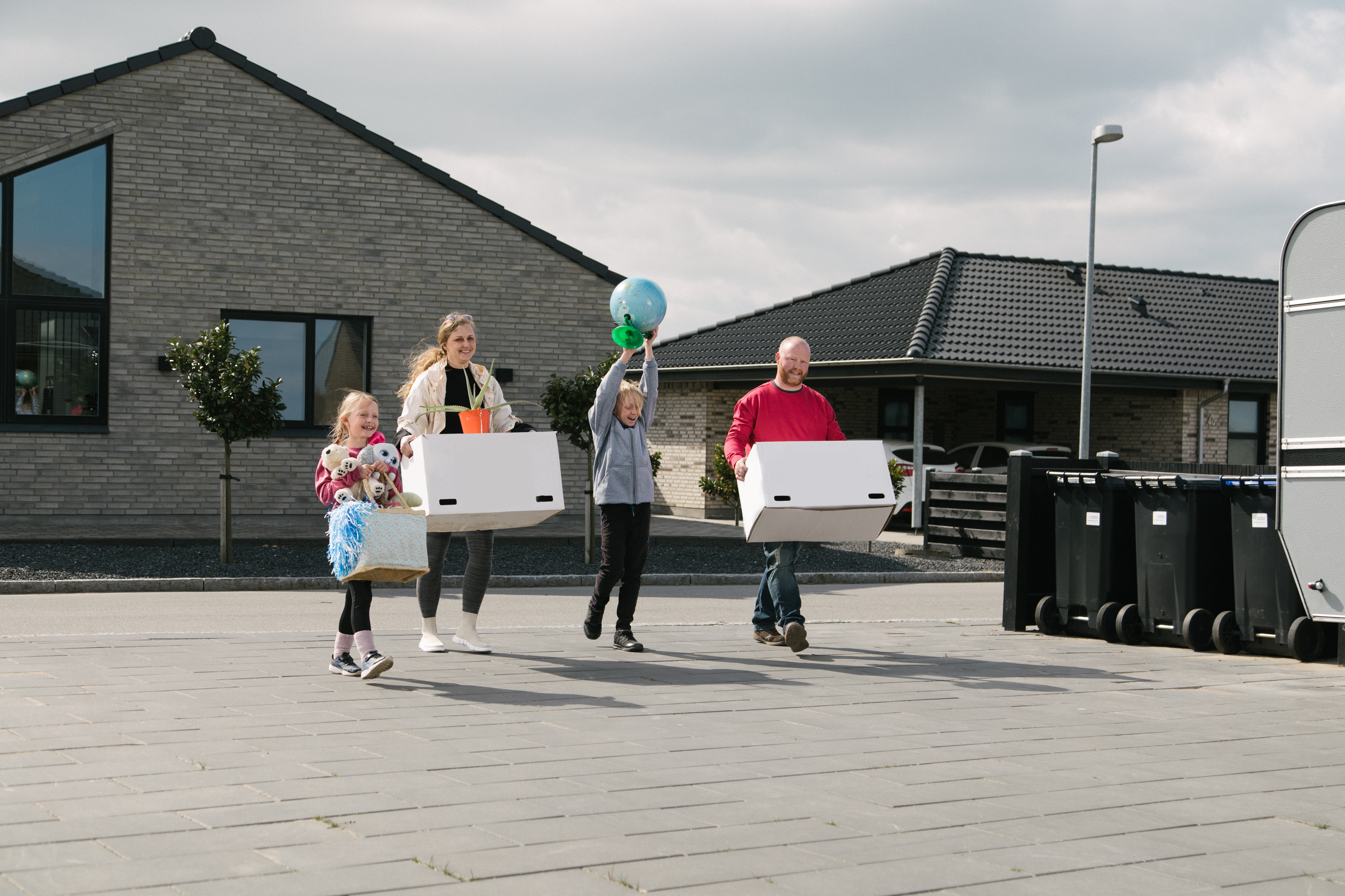 Familie med flyttekasser i nyt parcelhusområde
